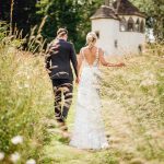 Homme House Bride and groom walk through wildflower meadow at Homme House Che Birch Hayes Photography 28