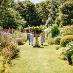 Homme House Guests walk up through Homme House walled garden for outdoor wedding ceremony 30
