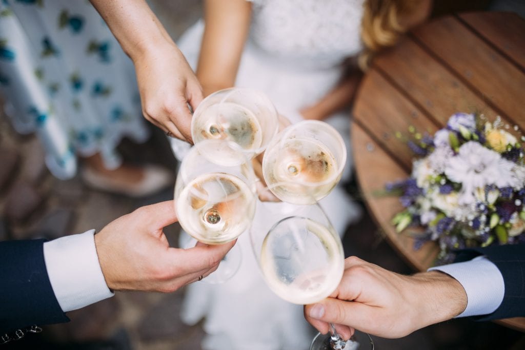The Ultimate Wedding Photography Checklist Four people make a celebratory toast on a wedding day 9