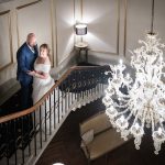 Bride and Groom on grand staircase with Chandelier