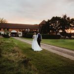 Cottesmore Hotel Golf and Country Club Bride and Groom with clubhouse.jpg 10