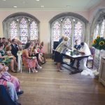 Ware Priory Bride and Groom signing register with guests min.jpg 4